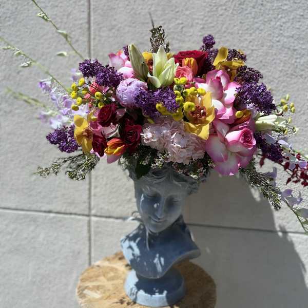 Colorful mixed bouquet arranged in a blue bust vase