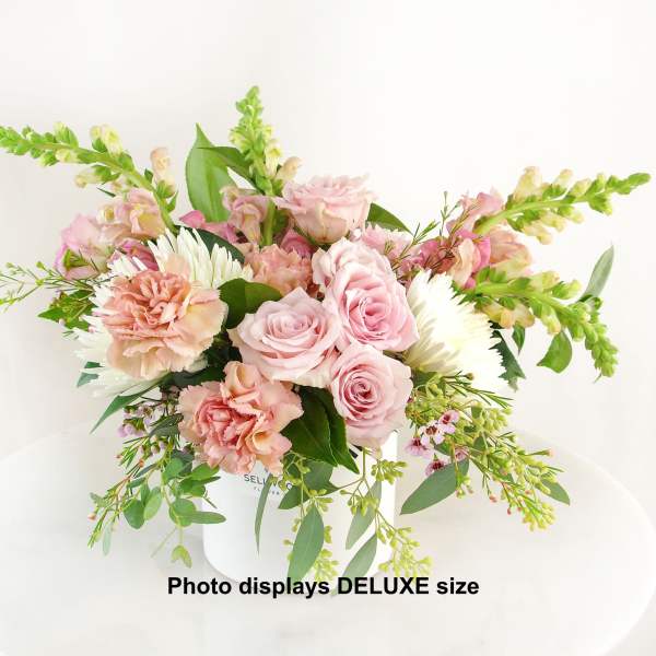 Pink roses and carnations with white daisies in a white vase