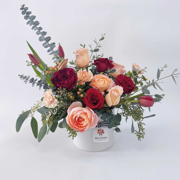 Mixed rose bouquet in a white hat box with eucalyptus accents