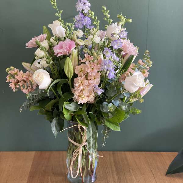 Pastel mixed bouquet in a glass vase with tall purple blooms