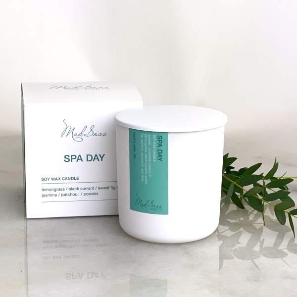 White soy wax candle in a box with green label and sprig of leaves