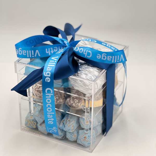Clear gift box filled with assorted chocolates and tied with a blue ribbon