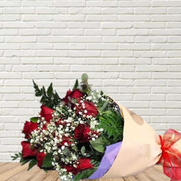Bouquet of red roses with baby's breath wrapped in beige paper