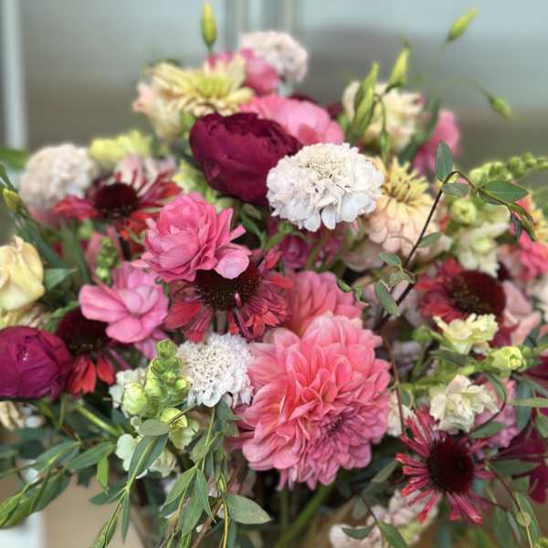 Mixed bouquet of pink, white, and burgundy flowers in a vase