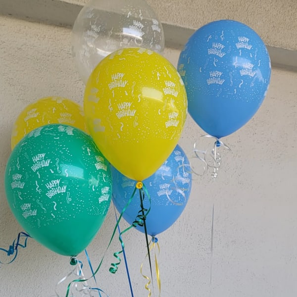 Cluster of colorful birthday balloons with curling ribbons
