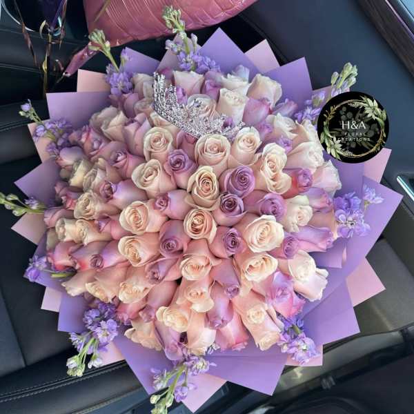 Bouquet of pink and lavender roses wrapped in purple paper