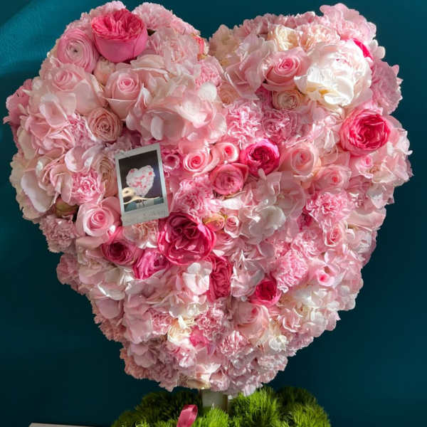 Heart-shaped pink floral arrangement in a box with a ribbon