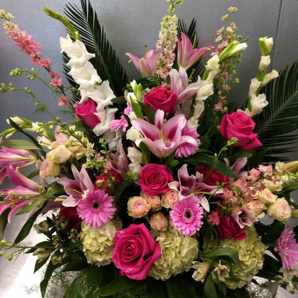 Large pink and white floral arrangement with roses, lilies, and gerbera daisies