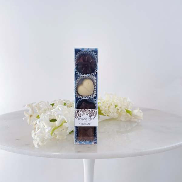 Box of chocolates with white flowers on a table