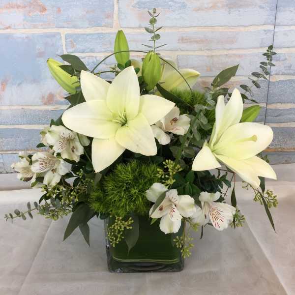 White lilies and white alstroemeria in a square glass vase