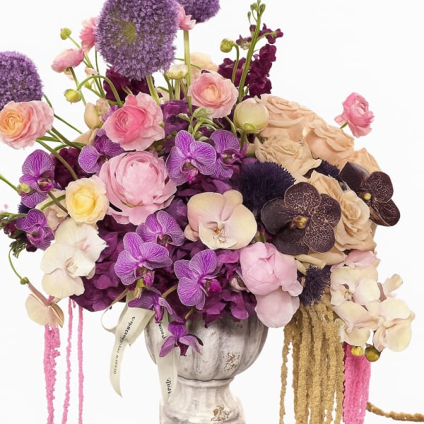 Lavender and pink floral arrangement in a pedestal vase
