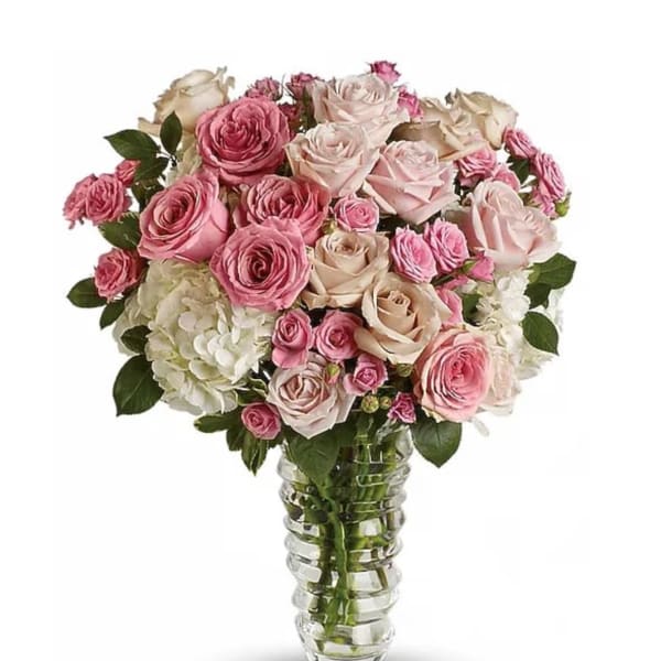 Pink and cream roses arranged in a clear glass vase