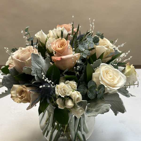 Bouquet of cream and peach roses in a glass vase