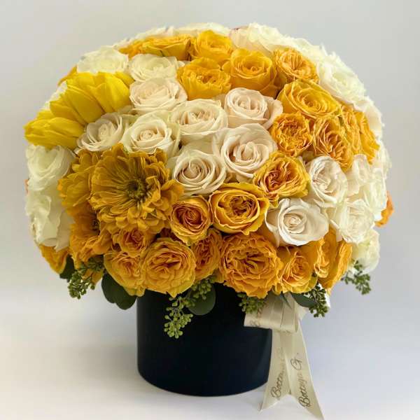 Yellow and white rose bouquet in a black hat box