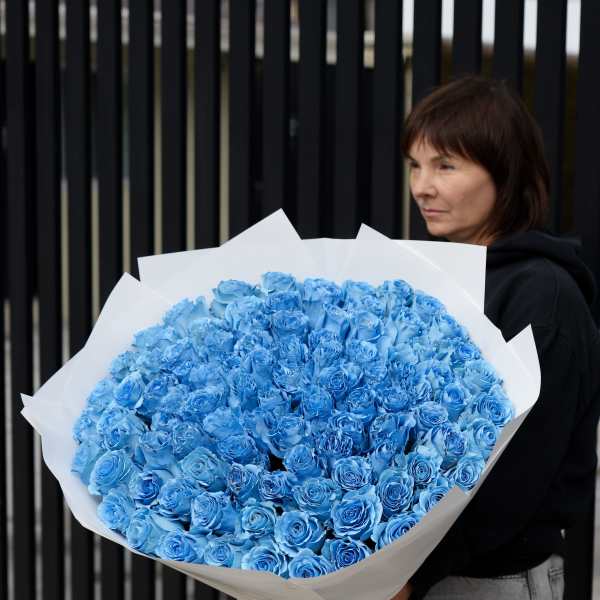 Large bouquet of blue roses wrapped in white paper