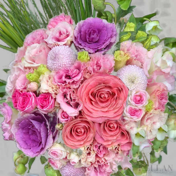 Tightly clustered bouquet of pink roses, ruffled blooms, and purple ornamental cabbages.
