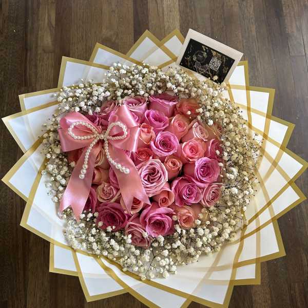 Pink rose bouquet with baby's breath and a satin bow