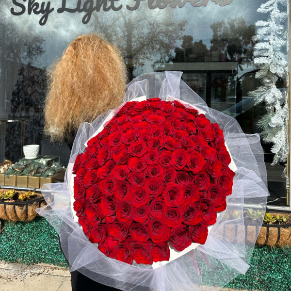 Large bouquet of red roses wrapped in white tulle