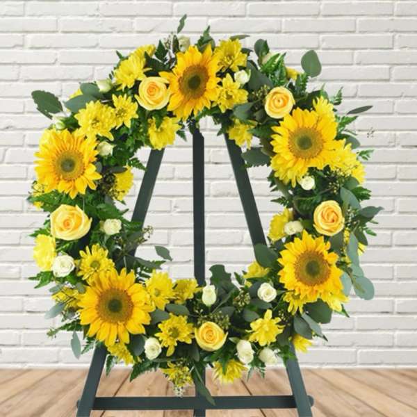 Yellow floral wreath on a black easel stand