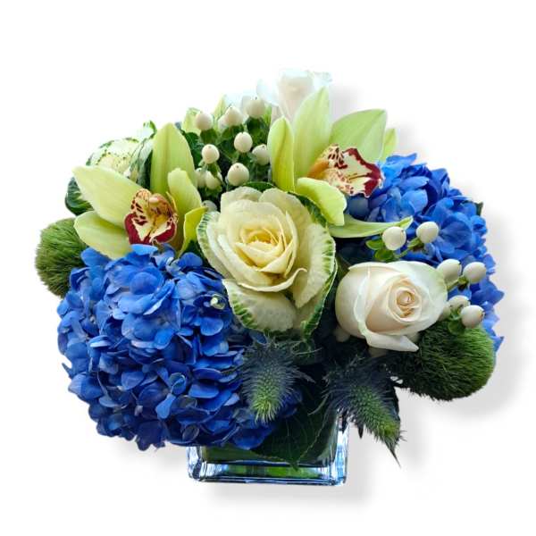 Blue hydrangeas and white roses in a square glass vase