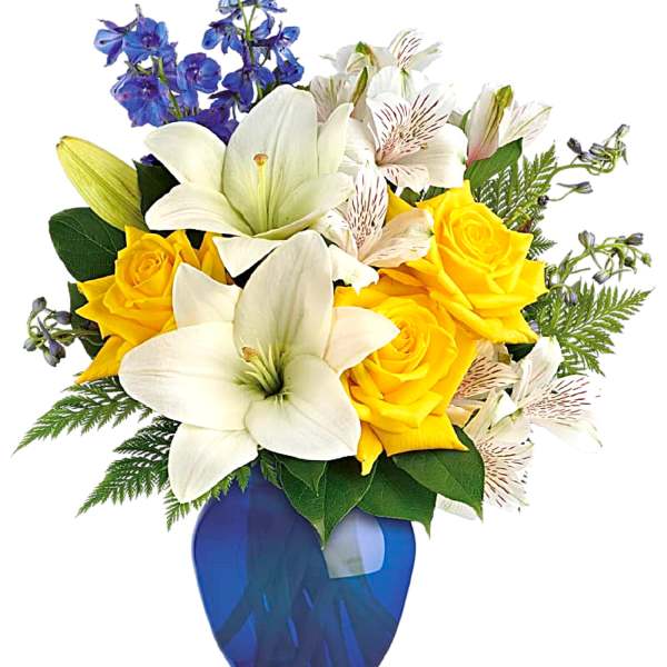 Yellow roses and white lilies in a blue vase with blue flowers
