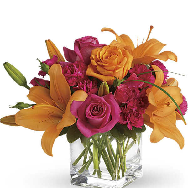 Orange lilies and pink roses arranged in a clear glass vase