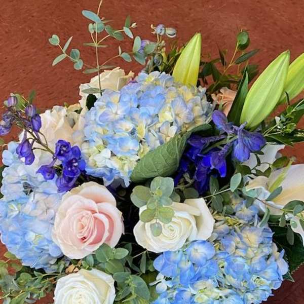 Blue hydrangeas with white and blush roses in a bouquet