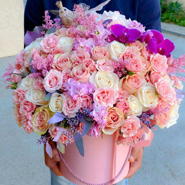 Pink and white rose bouquet in a pink hatbox with purple orchids