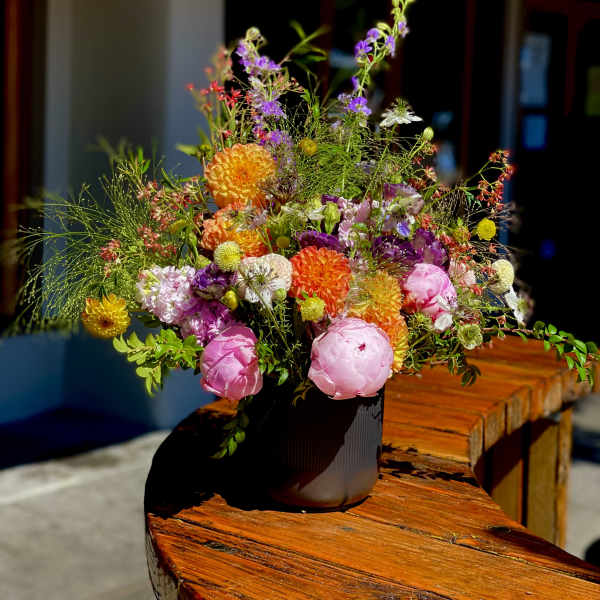 Colorful mixed flower arrangement in a dark vase