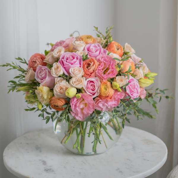 Pink and peach rose bouquet in a clear glass vase