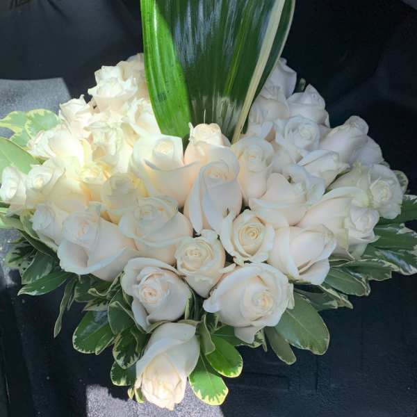 White rose bouquet with a large green leaf accent