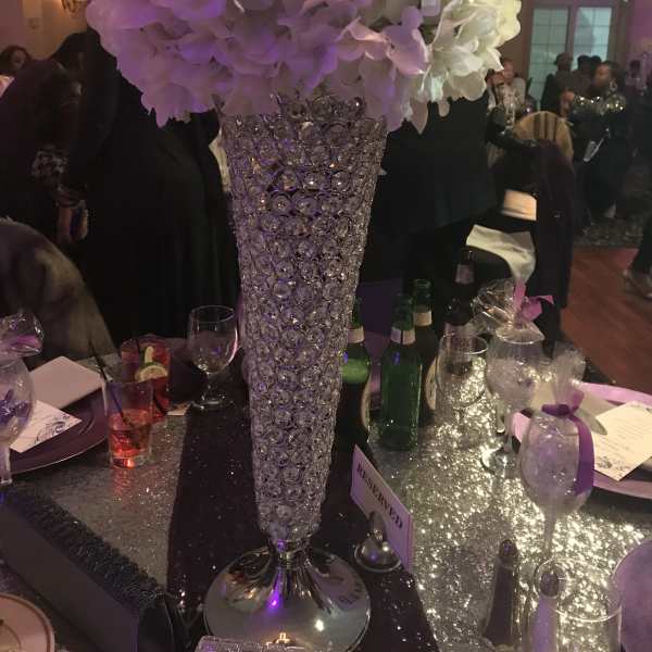 Tall white and lavender floral centerpiece in a crystal vase
