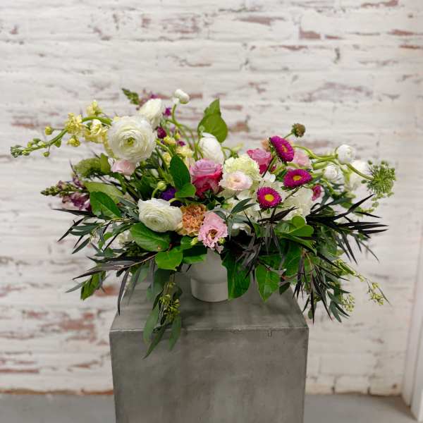 Mixed bouquet in a white vase with pink, white, and purple blooms