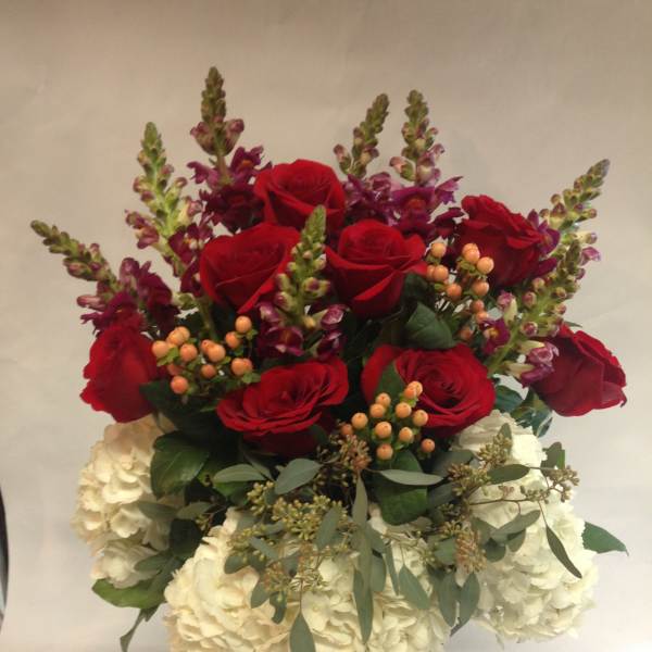 Bouquet of red roses and white hydrangeas in a burlap-wrapped vase