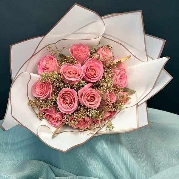 Bouquet of pink roses wrapped in white paper
