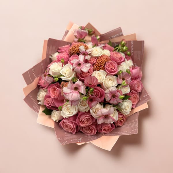 Pink and white rose bouquet with small pink flowers in decorative wrap