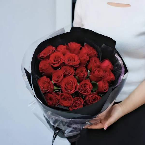 Bouquet of red roses wrapped in black paper