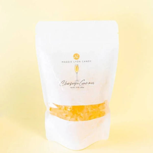White candy bag labeled Champagne Gummies on a pale yellow background