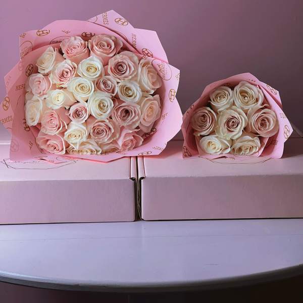 Two bouquets of pale pink and cream roses wrapped in pink paper