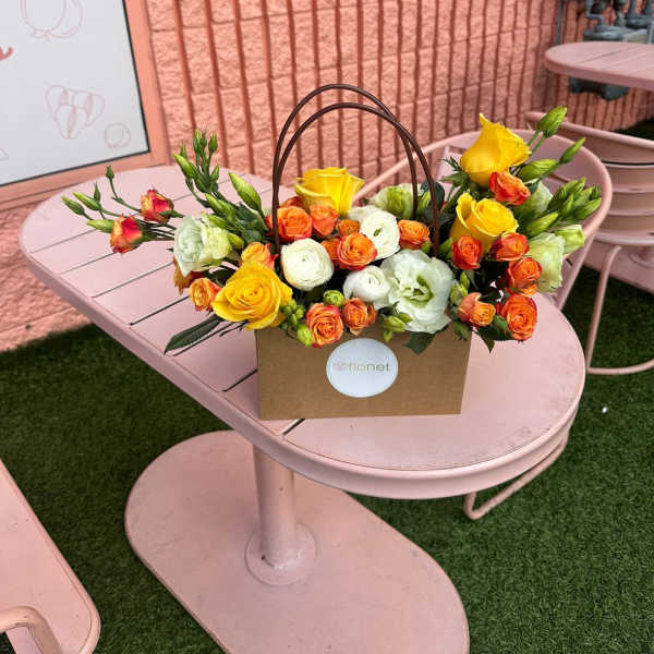 Yellow and orange roses in a brown handled box