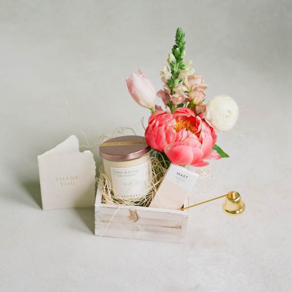 Gift basket with flowers, a candle, and a thank-you card