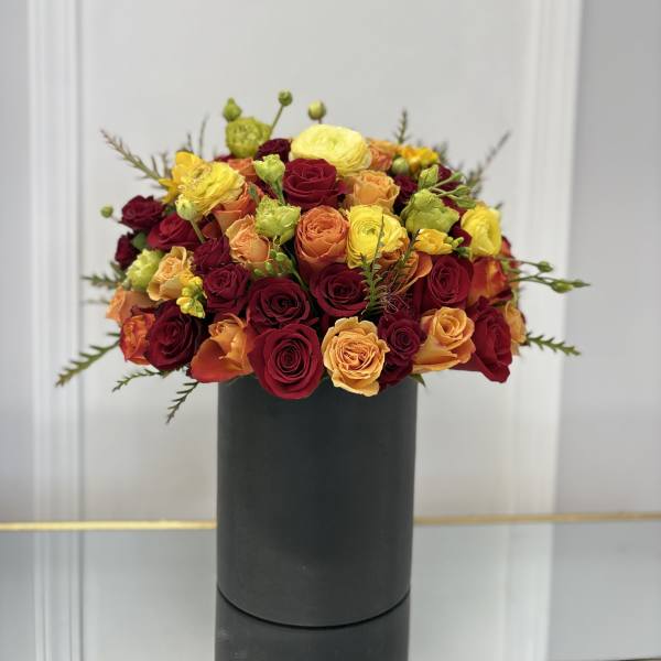 Mixed roses in a black cylindrical vase