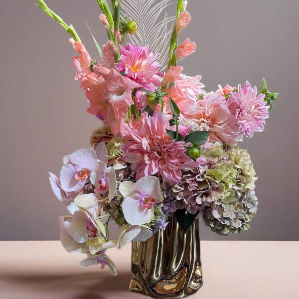 Pink and white floral arrangement in a metallic vase
