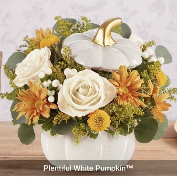 White pumpkin-shaped vase with white roses and yellow-orange flowers