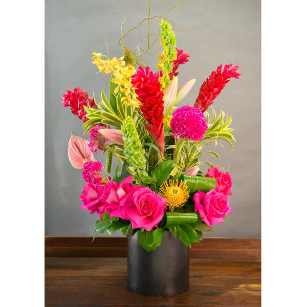 Bright tropical bouquet in a black vase with pink roses and red ginger flowers