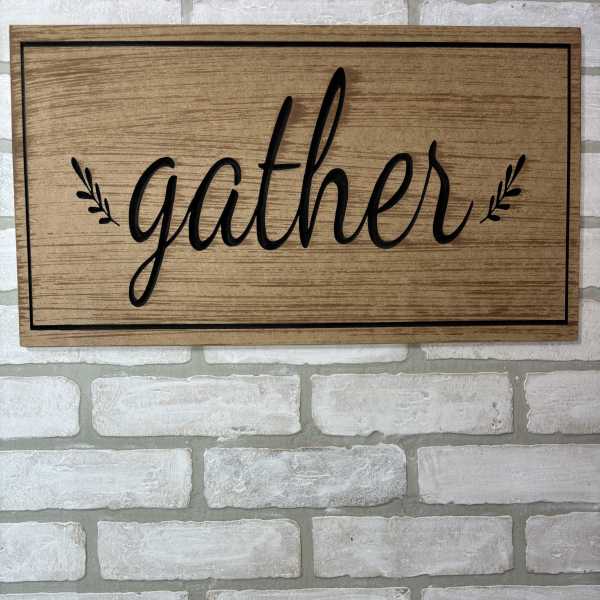 Wooden wall sign with the word "gather" in black script