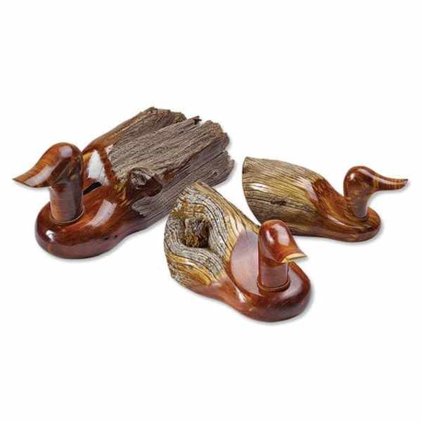 Three carved wooden duck figurines on a white background
