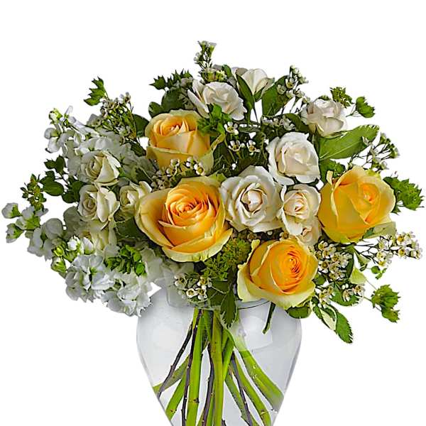 Yellow and white roses arranged in a clear glass vase