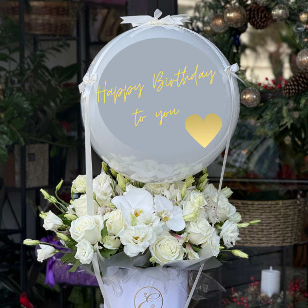 White flower arrangement with a birthday balloon in a white box