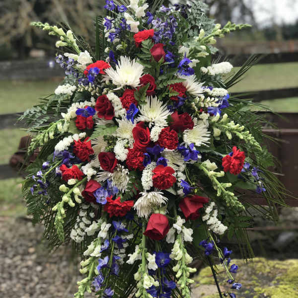 Large standing floral spray with red, white, and blue flowers